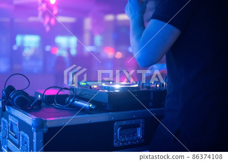 Close-Up of Dj Mixer Controller Desk in Night Club Disco Party. DJ Hands touching Buttons and Close-Up of Dj Mixer Controller Desk in Night Club Disco Party. DJ Hands touching Buttons and 86374108