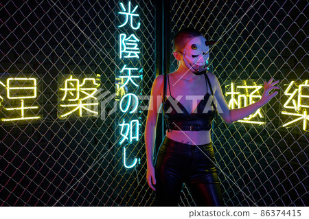 Young cyberpunk female in monster mask and black leather clothes Young cyberpunk female in monster mask and black leather clothes 86374415