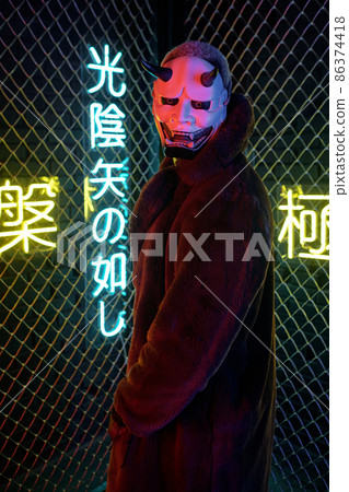 African man in monster mask and long brown furcoat African man in monster mask and long brown furcoat 86374418
