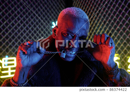 Young African man with chain between his clenched teeth 86374422