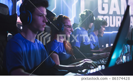 Focused men and women playing video game during competition 86374428