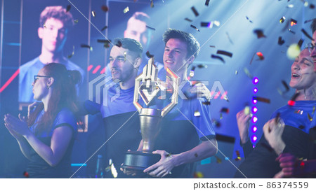 Team of gamers with golden cup celebrating victory 86374559