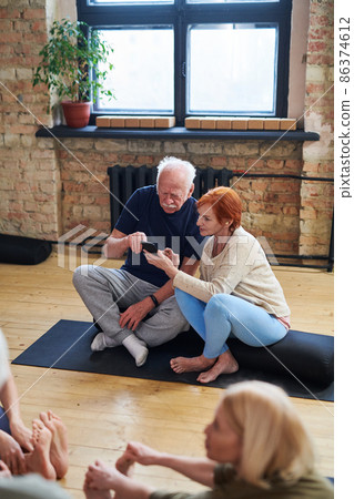 Senior couple using phone in health club 86374612