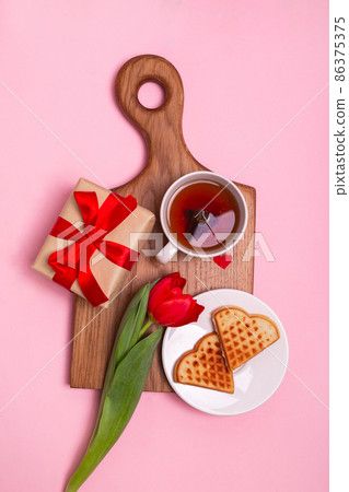 Valentine's Day breakfast in bed. Gift, tea Belgian waffles flower, , hearts on pink background. Valentines day concept. Valentine's Day breakfast in bed. Gift, tea Belgian waffles flower, , hearts on pink background. Valentines day concept. 86375375