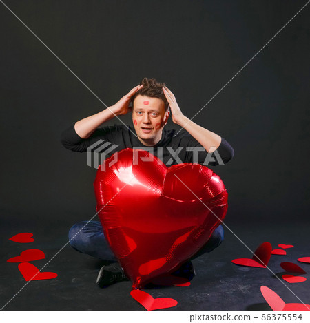 valentines red heart, an inflatable balloon in hands, beautiful holiday. On a black background cheerful happy, young 86375554
