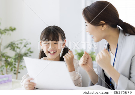 Girl elementary school student who is pleased with the result of the test at the cram school Girl elementary school student who is pleased with the result of the test at the cram school 86375679