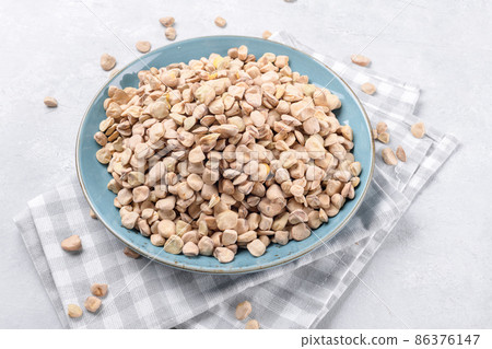 Cicerchia or indian pea on a ceramic plate with napkin on grey table background, gluten free food, close up 86376147