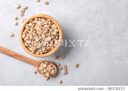 Cicerchia or indian pea in a wooden bowl and spoon on grey table background, gluten free food, flat lay 86376151