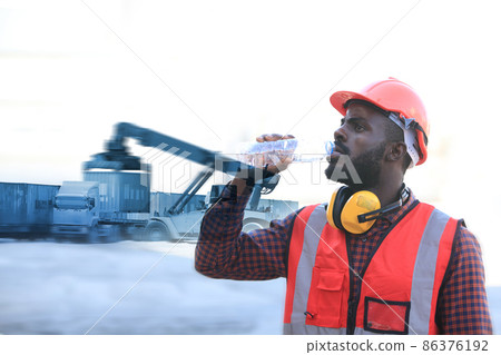 African American engineer  working in container area  logistics transportation import export or shipping industry , delivery  and logistics concept container truck  transport or free-zone area 86376192