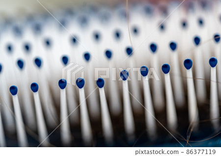 Selective focus on bristles of a hairbrush with tangled hair Selective focus on bristles of a hairbrush with tangled hair 86377119