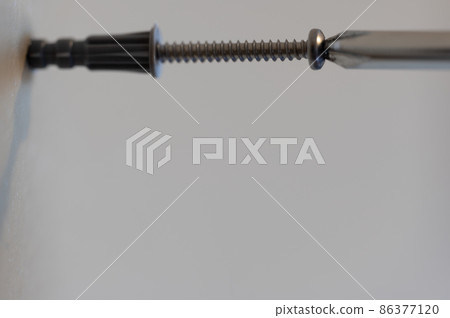 Selective focus on a typical drywall anchor installation . 86377120