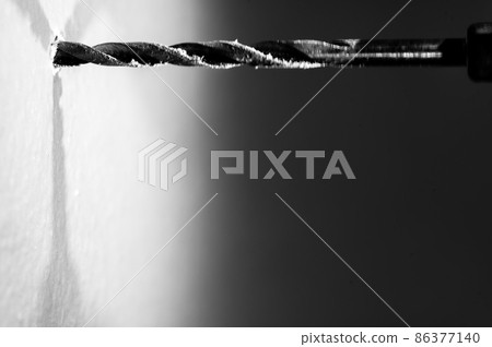 Selective focus on point of penetration of a drill bit making a pilot hole in drywall Selective focus on point of penetration of a drill bit making a pilot hole in drywall 86377140