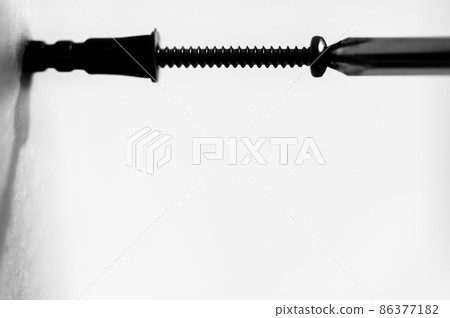 Selective focus on a typical drywall anchor installation . 86377182