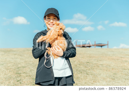 一個穿著運動服遛狗的女人(拿著) 一個穿著運動服遛狗的女人(拿著) 86378924