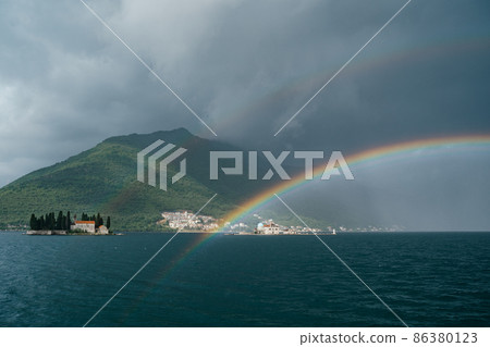 Rainbow over small islands in the Kotor Bay near Perast Rainbow over small islands in the Kotor Bay near Perast 86380123