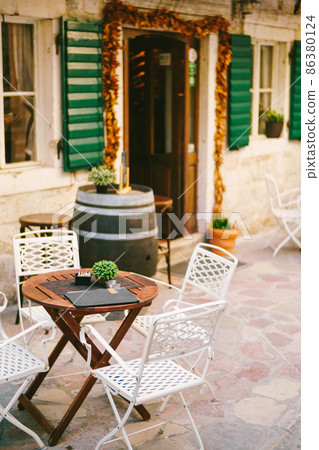 Barrel table near the entrance to a rustic cafe Barrel table near the entrance to a rustic cafe 86380124