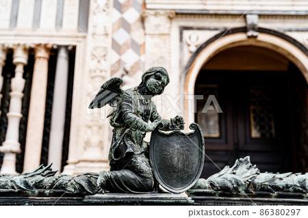 Statue of an angel with a shield near the entrance to the Colleoni Chapel. Bergamo, Italy Statue of an angel with a shield near the entrance to the Colleoni Chapel. Bergamo, Italy 86380297