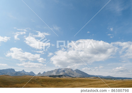 High mountain range over a valley against a blue sky in Durmitor National Park 86380798