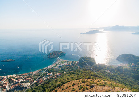 View from the mountain to the island of Sveti Stefan in bright sunlight. Montenegro View from the mountain to the island of Sveti Stefan in bright sunlight. Montenegro 86381207