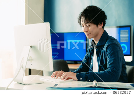 A man heading to a computer A man heading to a computer 86382937