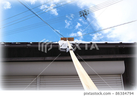 [HDR 風格] 使用自製的除雪工具清除屋頂上的雪的場景，刀片附在長桿的尖端。 86384794