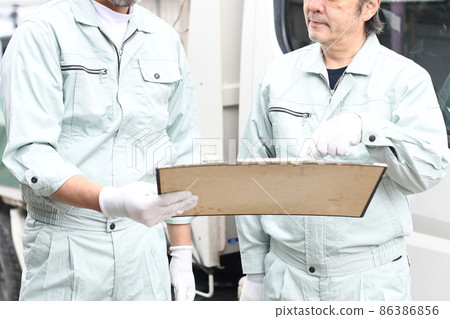 查看卡車前的圖紙 穿著工作服的中老年人 查看卡車前的圖紙 穿著工作服的中老年人 86386856