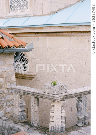 Stone balustrade near the wall of an ancient building. Close-up Stone balustrade near the wall of an ancient building. Close-up 86387498