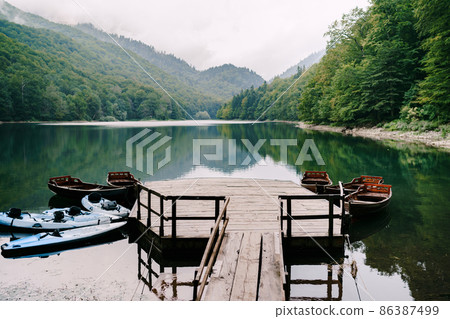 Small pier with moored boats on the lake in the Biogradska Gora park. Montenegro 86387499