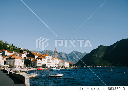 Perast embankment with stone houses and moored boats. Montenegro 86387643