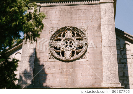 Rose window on the stone facade of an old church Rose window on the stone facade of an old church 86387705