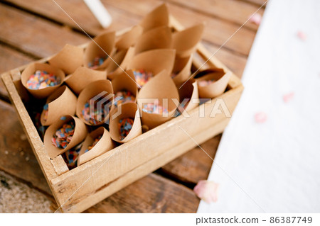 Wooden box with rolled paper bags with flower petals 86387749