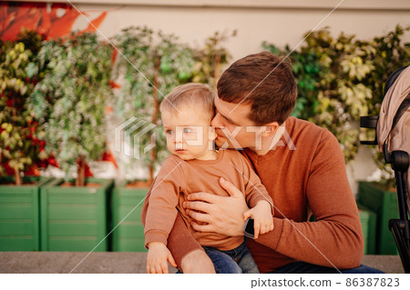 dad kisses and hugs with his son. games and walks with children.  86387823