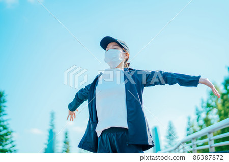 A woman wearing a mask and taking a deep breath 86387872