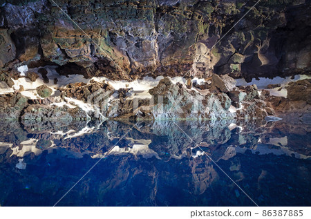 Cave on Lanzarote, reflection in the blue cold water Cave on Lanzarote, reflection in the blue cold water 86387885