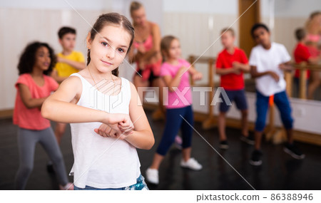 Tween girl training vigorous dance during group class Tween girl training vigorous dance during group class 86388946