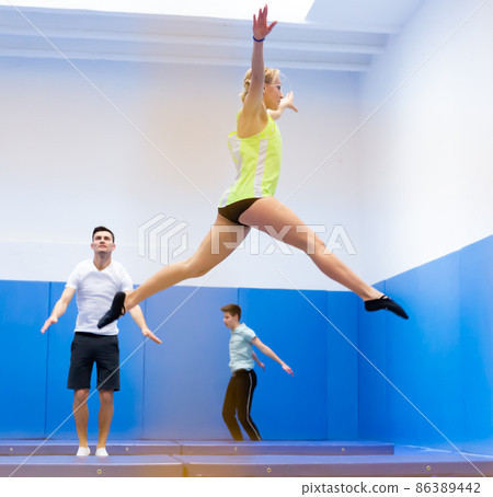 Woman training in trampoline center Woman training in trampoline center 86389442