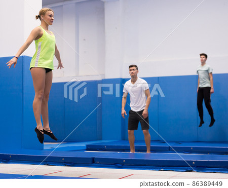 Woman jumping in trampoline center 86389449