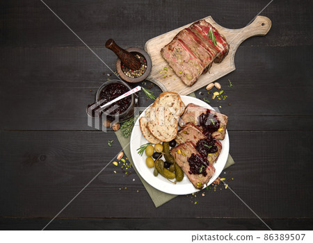 Sliced Traditional French terrine covered with bacon on dark wooden background Sliced Traditional French terrine covered with bacon on dark wooden background 86389507