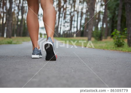 Young woman running outdoors in a city park 86389779