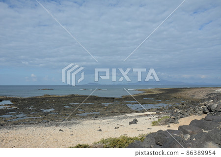 Bay full of volcanic stones in Bajo Ballena. El Cotillo La Oliva Fuerteventura Canary Islands. Bay full of volcanic stones in Bajo Ballena. El Cotillo La Oliva Fuerteventura Canary Islands. 86389954