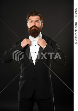 elegant butler in tuxedo on black background, bow tie elegant butler in tuxedo on black background, bow tie 86390292
