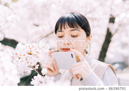 Women taking photos of cherry blossoms 86390791