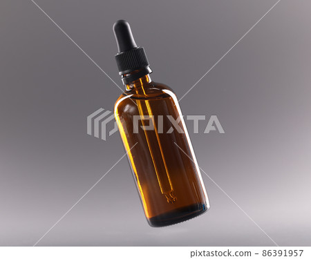 Glass bottle with cosmetic oil on gray background closeup 86391957
