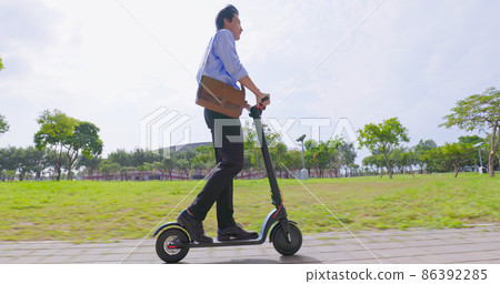 man riding electric scooter 86392285