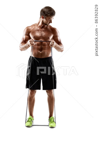 Handsome fitness man working out with rubber band, studio shot. 86392829