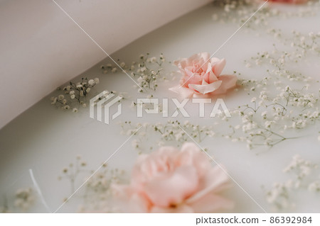 Cloudy milky soap water in a bath with rose flowers 86392984