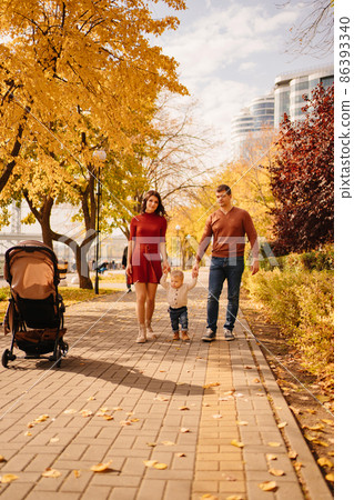 a family with a child on an autumn walk around the city 86393340