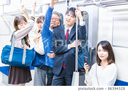 Passengers on a crowded train 86394328