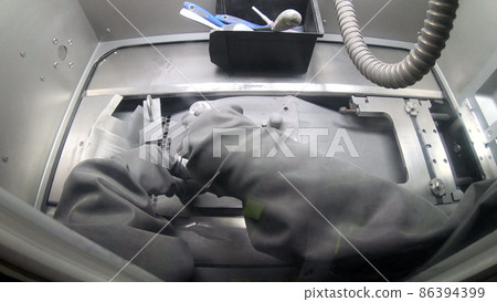 Worker in gloves unscrews platform with printed models on 3d printer for metal 86394399