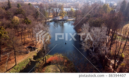 Arial drone view flight over lake in park on sunny autumn day 86394407